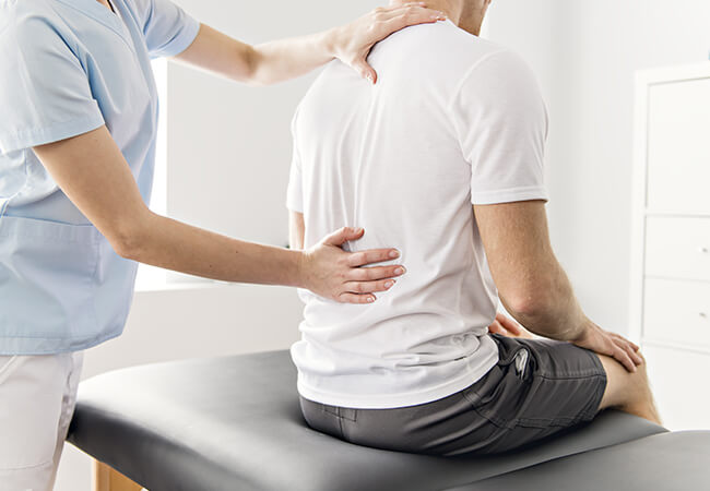 man with back pain getting physical therapy